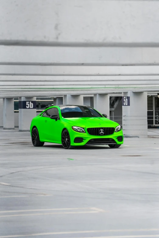 the lime green car is parked in a parking lot