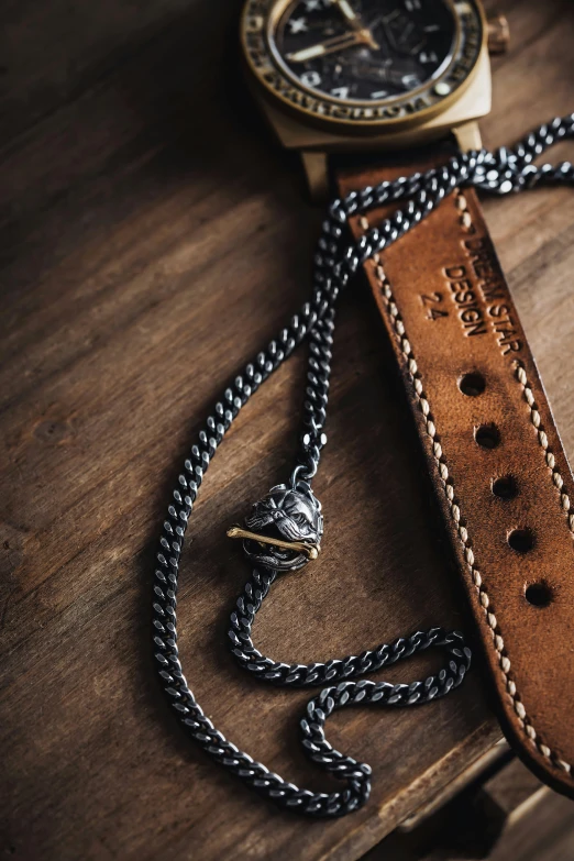 a wooden watch on top of a black leather watch strap