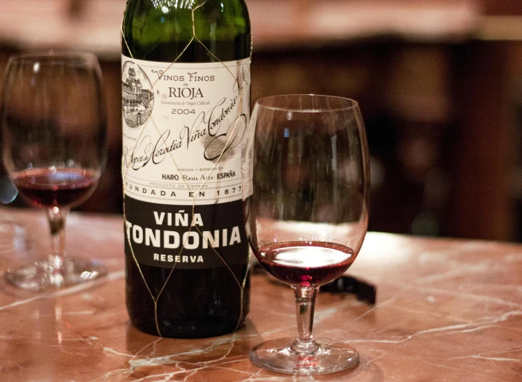 two wine glasses on a table and a bottle of wine