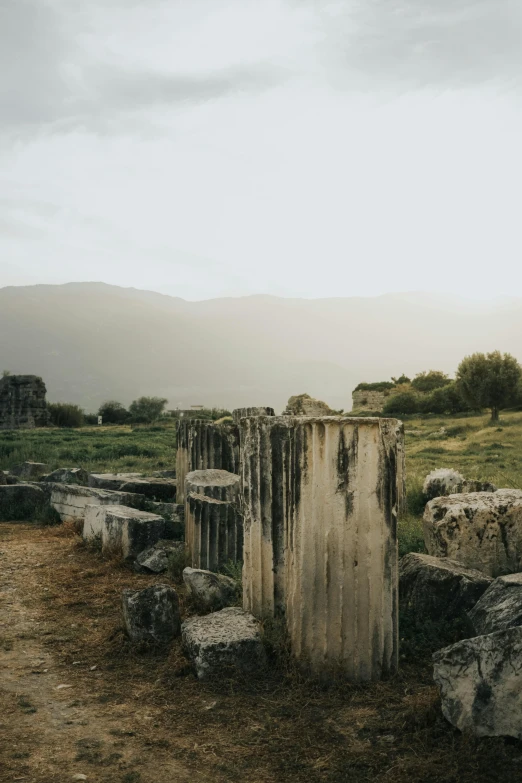 a old rock structure surrounded by grass and rocks