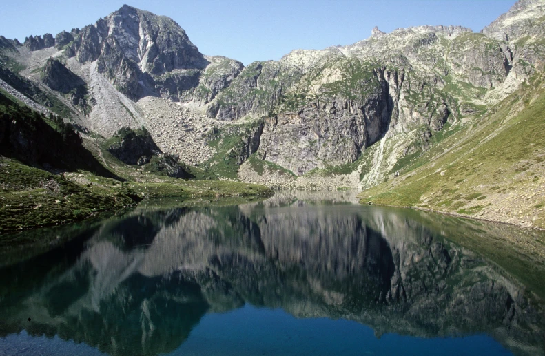 a lake on the side of a mountain range in the wilderness