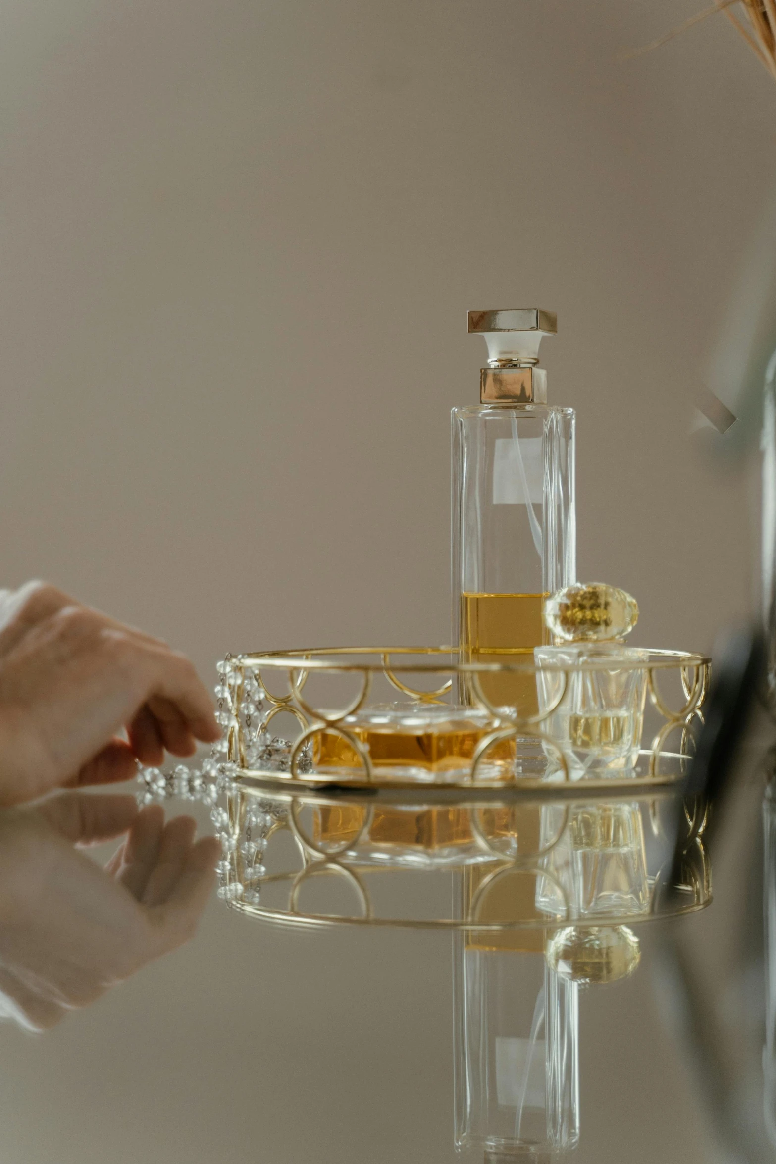 a hand is pressing ons on a glass bottle with a metal stand