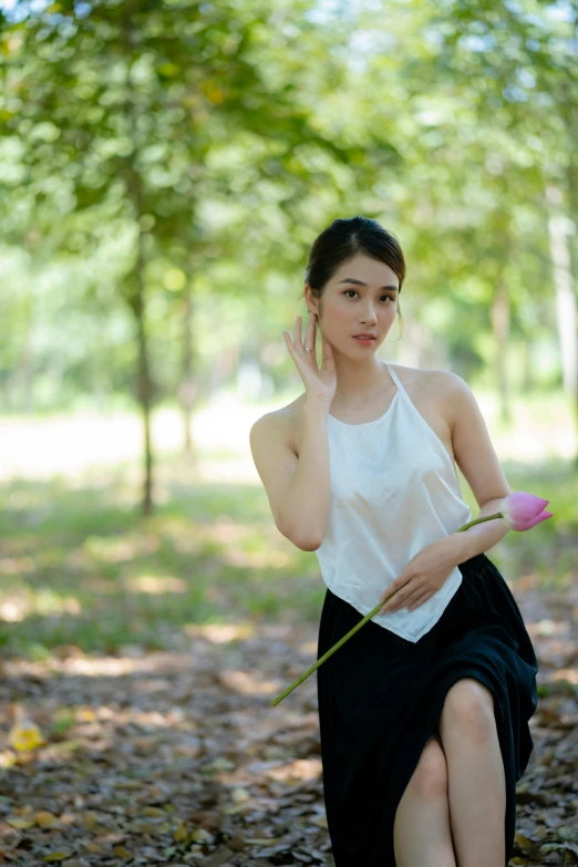 a  in a skirt holding a flower