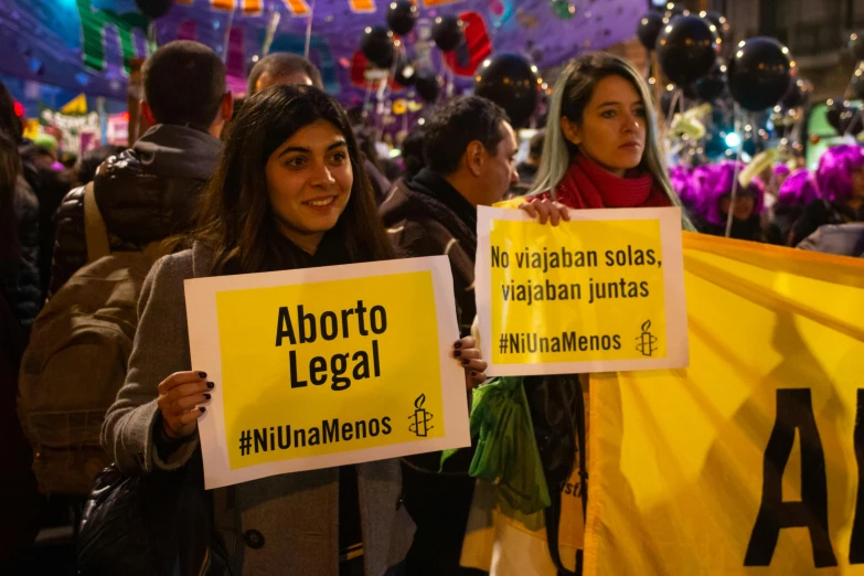 people holding signs saying, aborto legal and no bailage