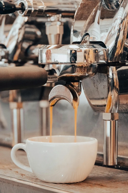 espresso machine being poured into cup on table