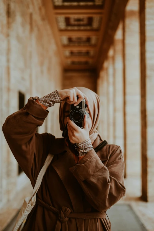 woman taking a pograph with her camera on a long hallway