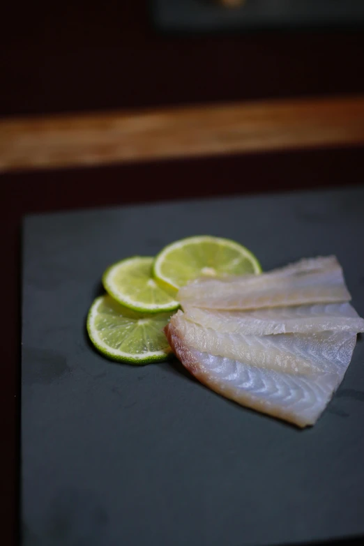 fish slices with limes and water on the side