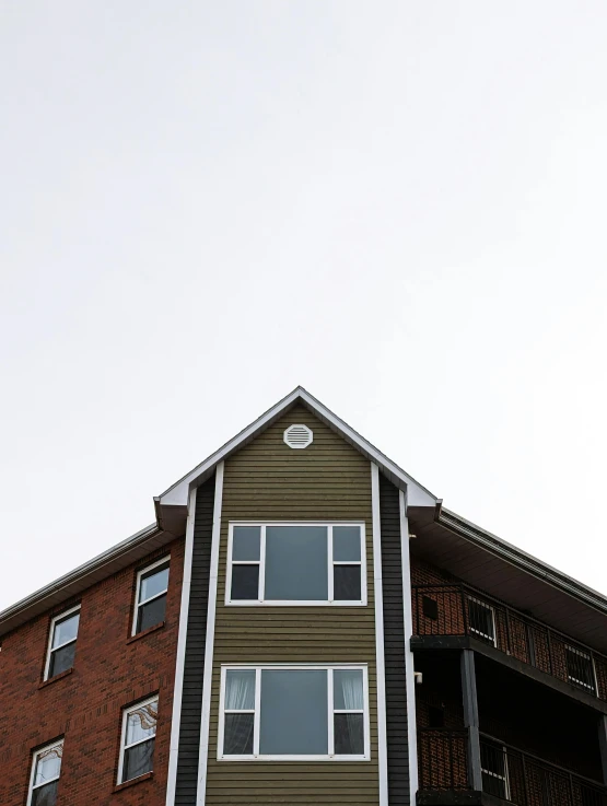 a tall house sits next to an apartment building