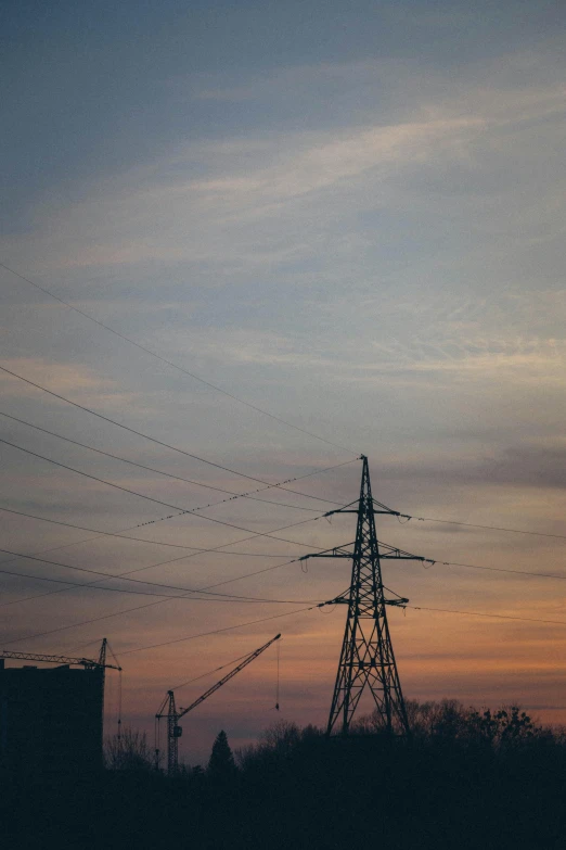 a sky is full of power lines with a building in the background