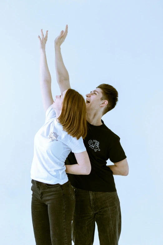 two people reaching for a frisbee on the ground