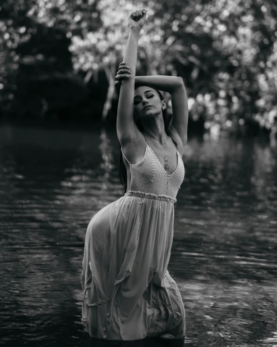 a woman is shown in water on the edge of a river