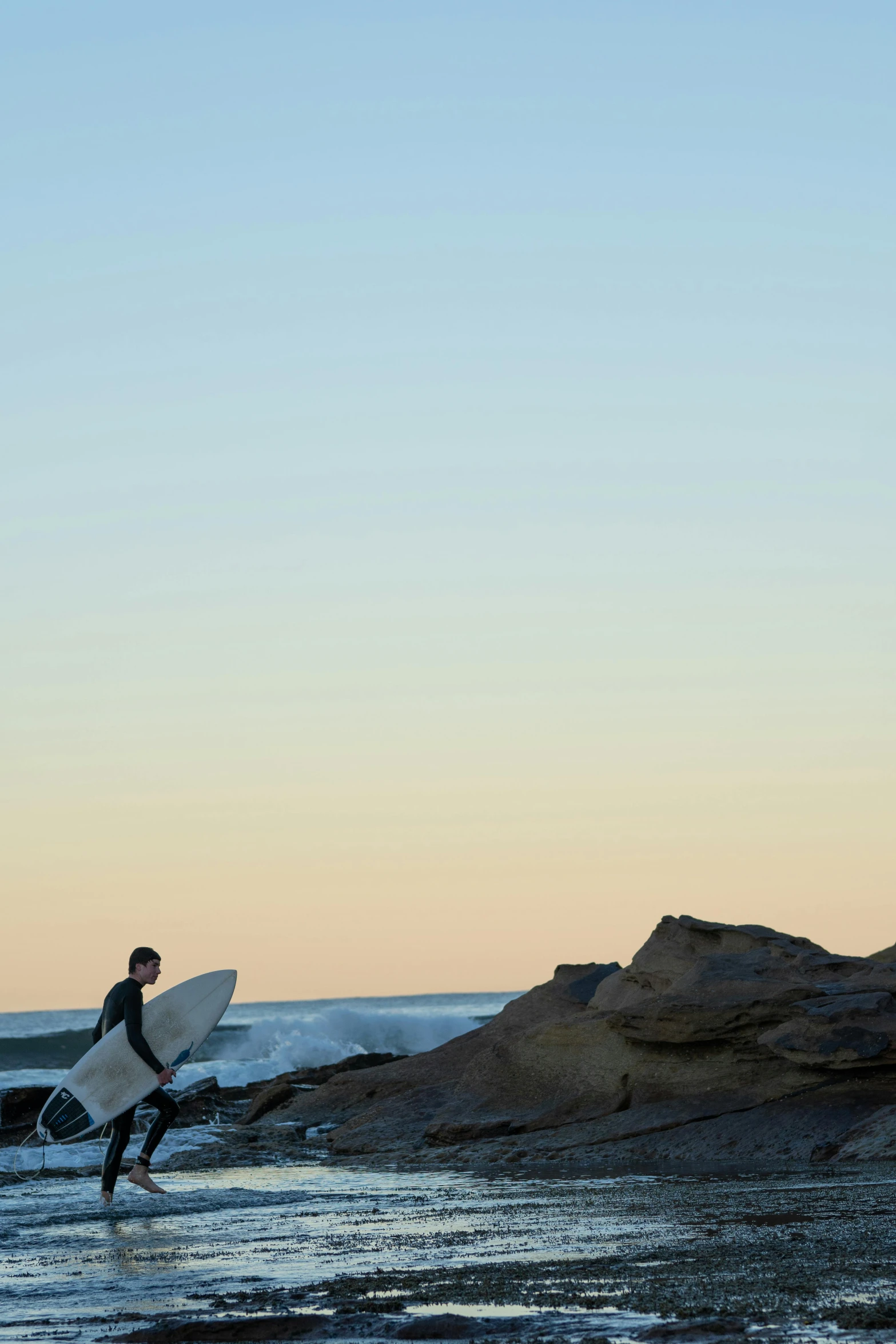 two men walking on the shore with their surfboards