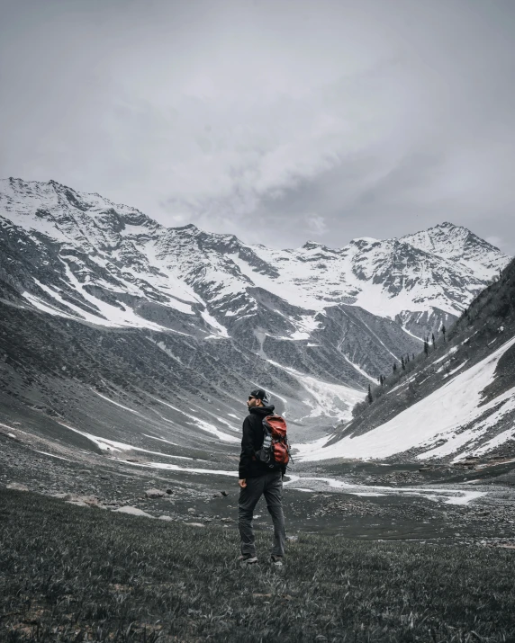 two people are standing in front of snow covered mountains