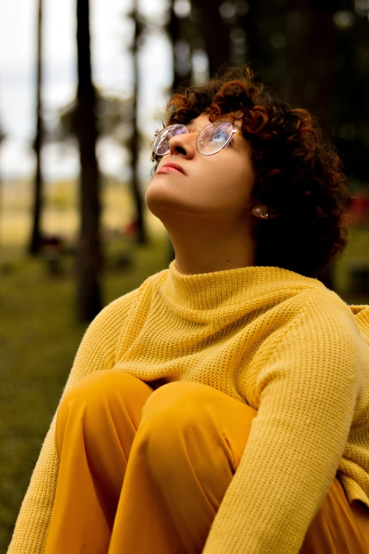 a woman is wearing glasses and sitting on a bench