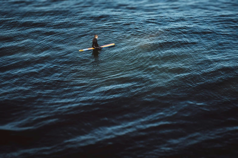 a person with a surfboard in the middle of some water