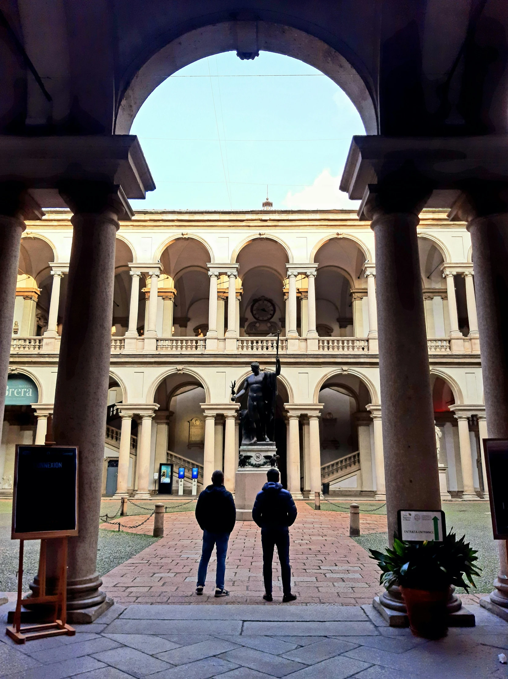 people are standing underneath a stone covered building