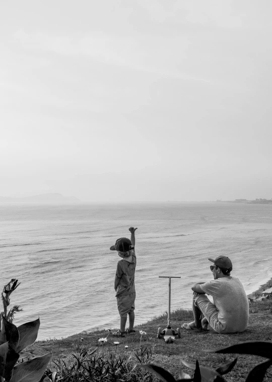 a man and a child looking out at the water