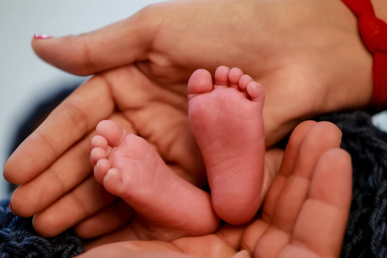 someone holding up the feet of their baby