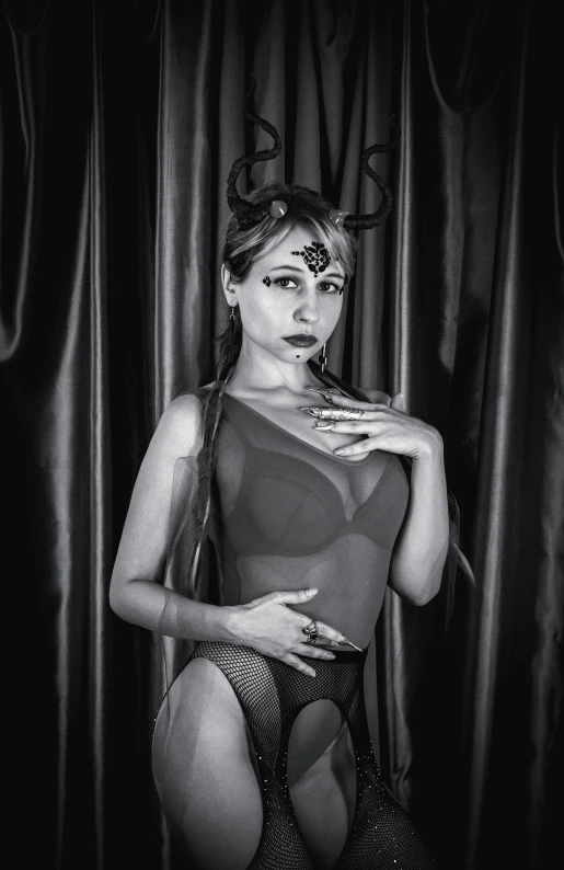 a woman in lingerie posing against curtain