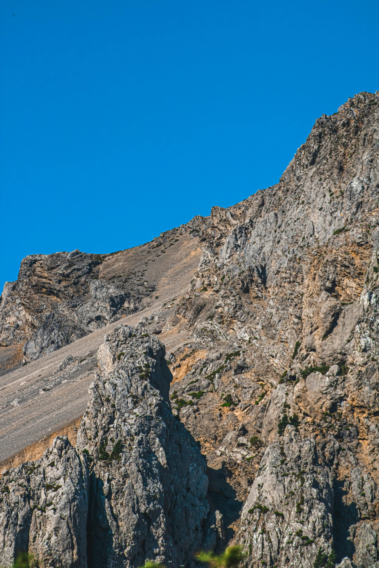 a rock cliff with blue sky as background