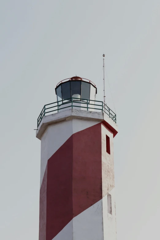 the lighthouse is red and white and it has a brown and white stripe