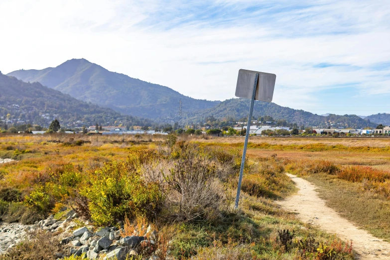 a dry dirt field with a very tall mountain range in the background