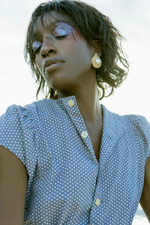 a woman with large yellow earrings on her forehead