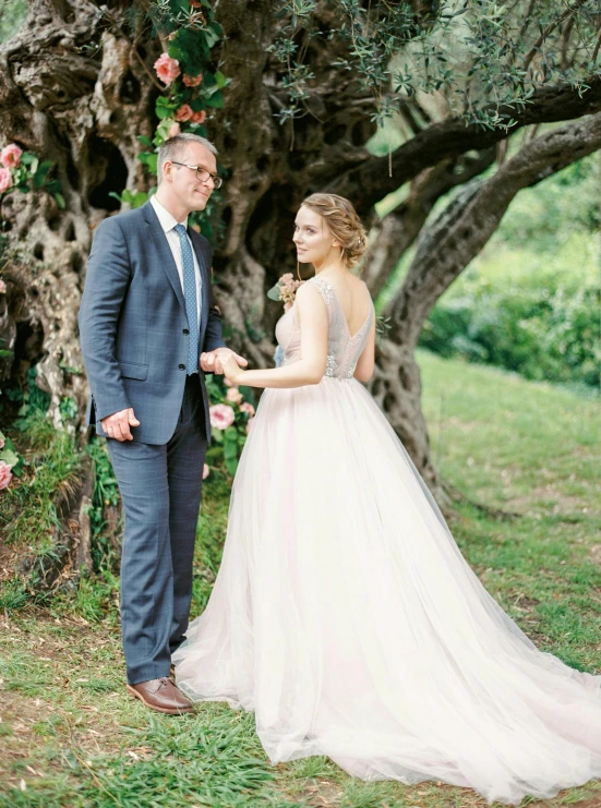 an engaged couple standing in the grass together