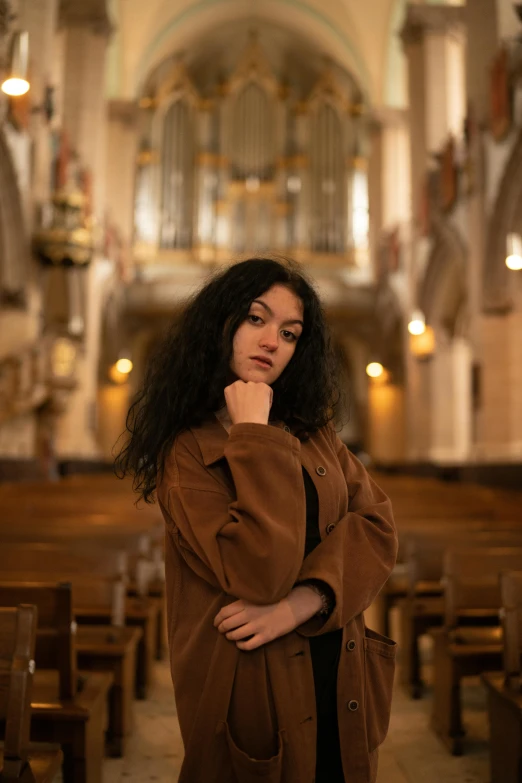 a woman is standing in a church and looking up at the ceiling