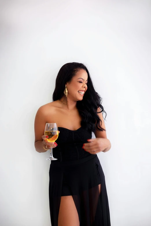 a woman in black holding a wine glass and smiling