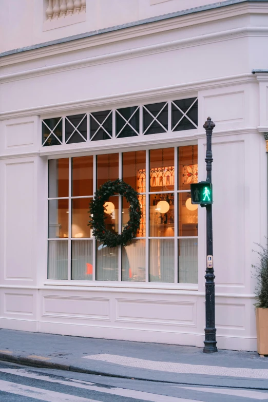 a green christmas wreath is on the window