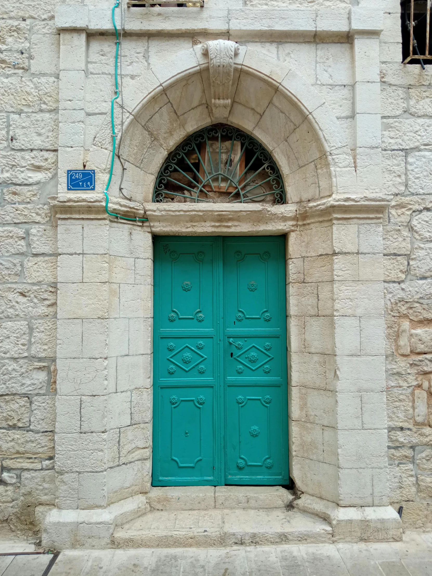 this is a turquoise green door that is above a window