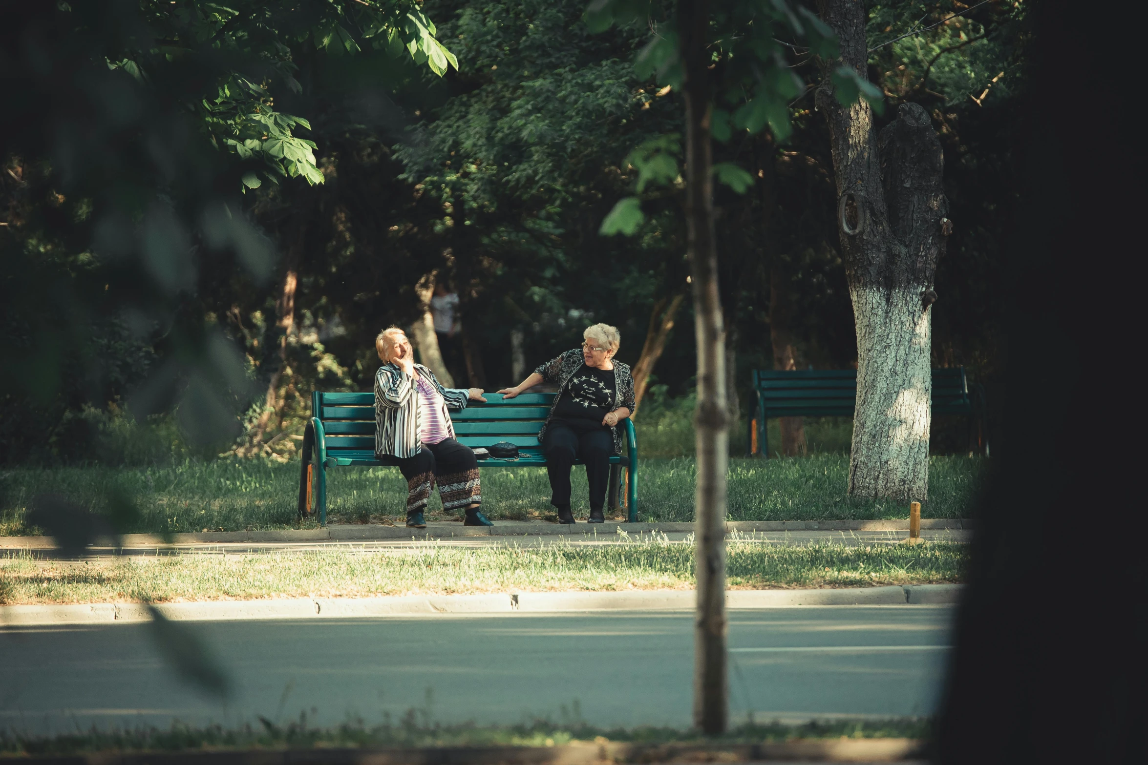 a couple of people sitting on top of a wooden bench