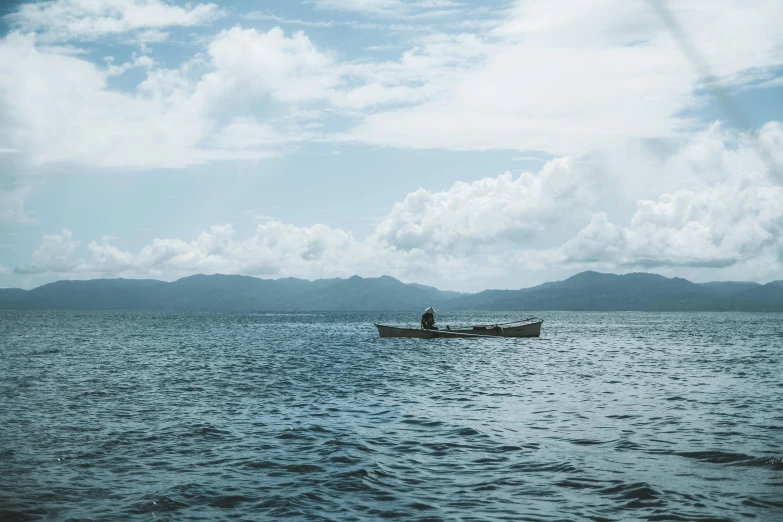 a man in a boat floating on top of a lake