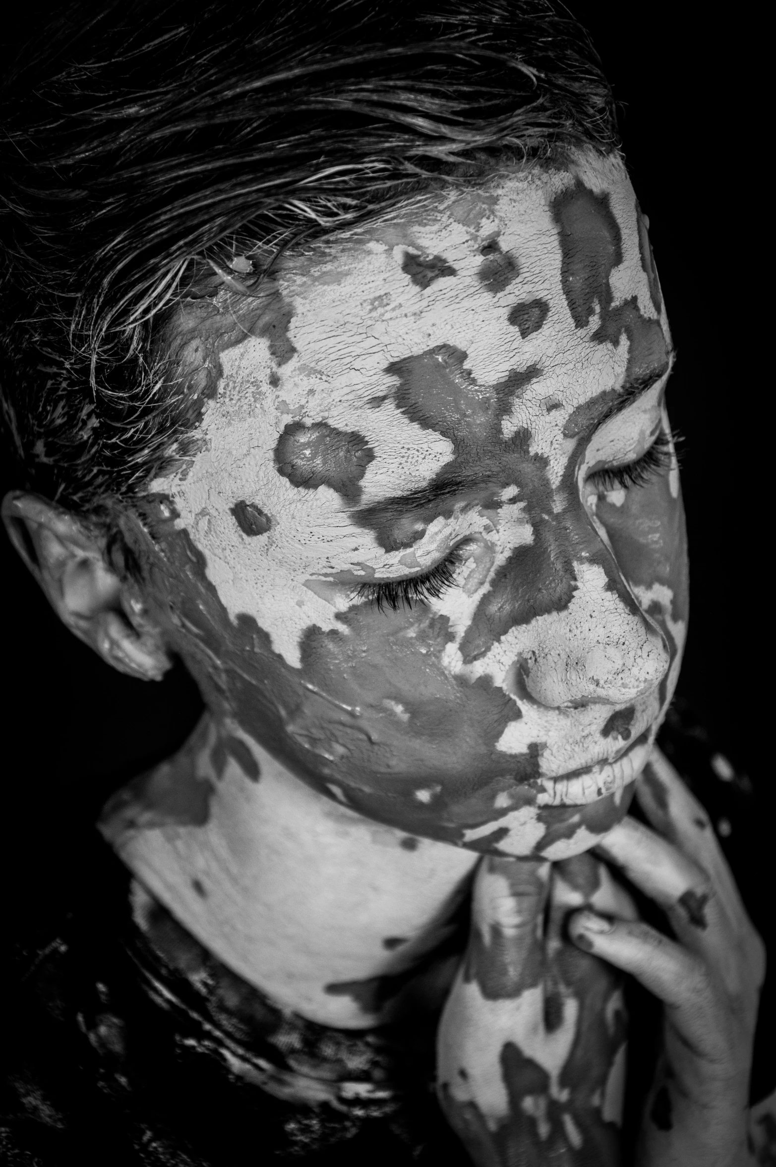 an old black and white po of a person with facial paint on