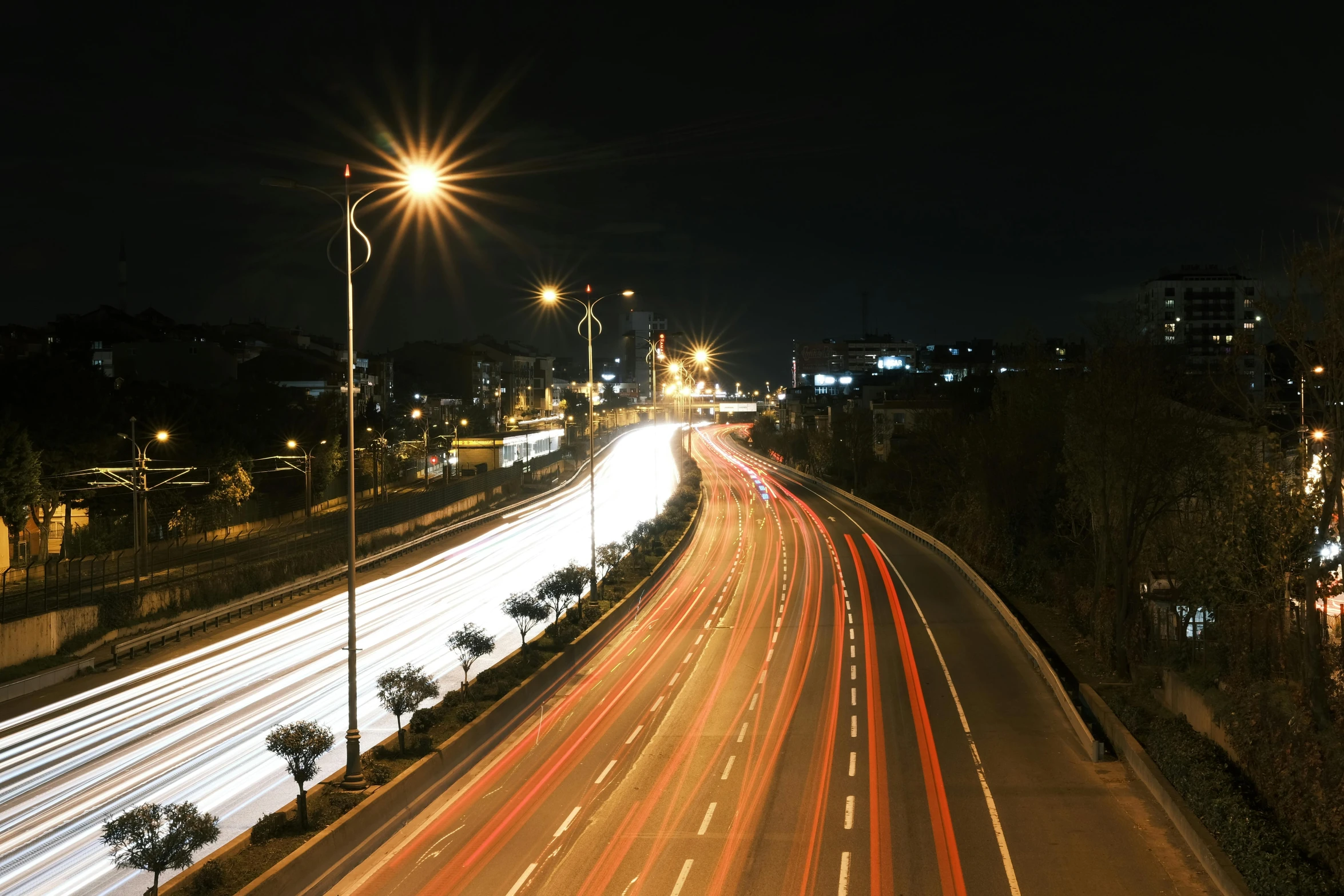 some cars are traveling down the highway at night