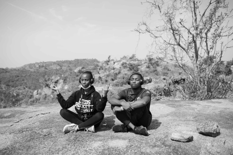 two people sit on a hillside and talk