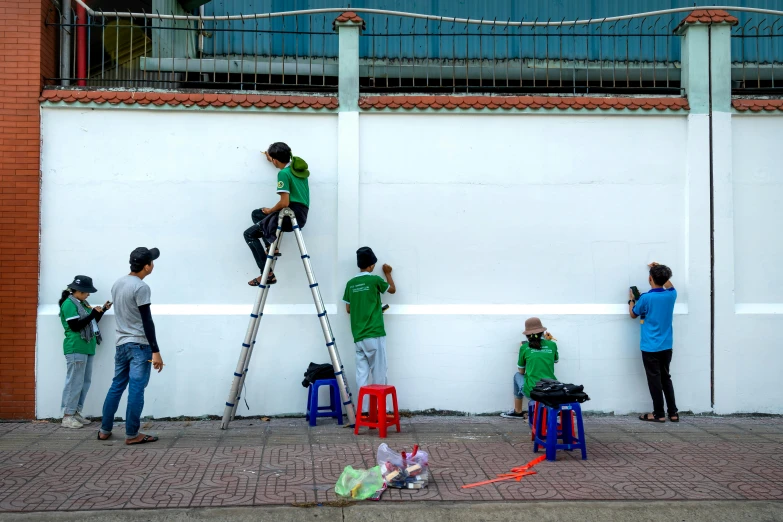 two men on a ladder with buckets climbing up to a wall