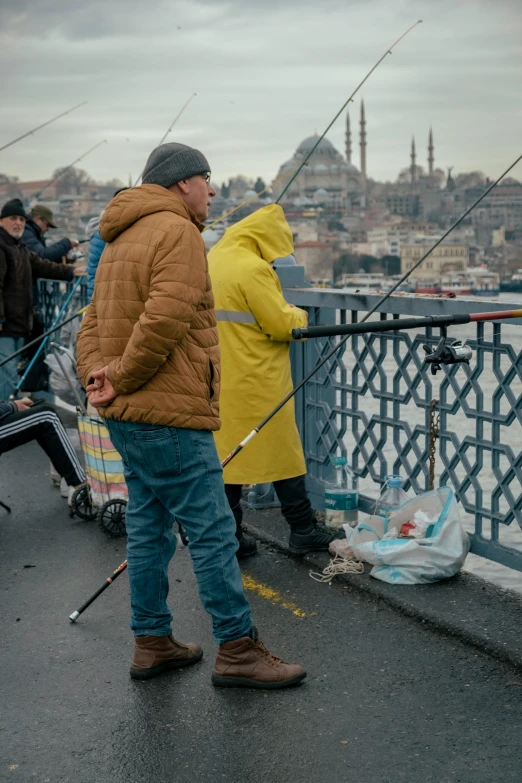 a person standing next to another person fishing