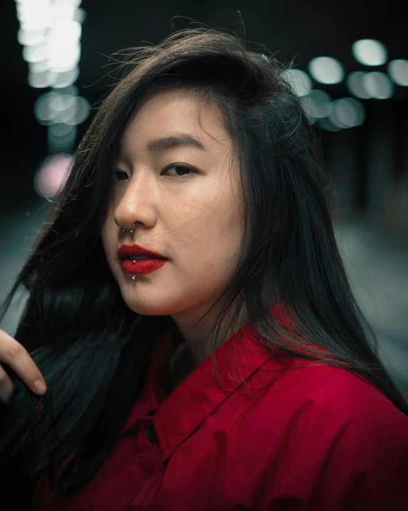 an asian woman wearing a red blouse and dark hair