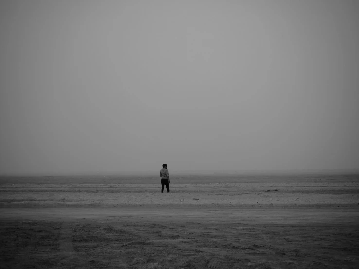 a lone person in the middle of an empty beach