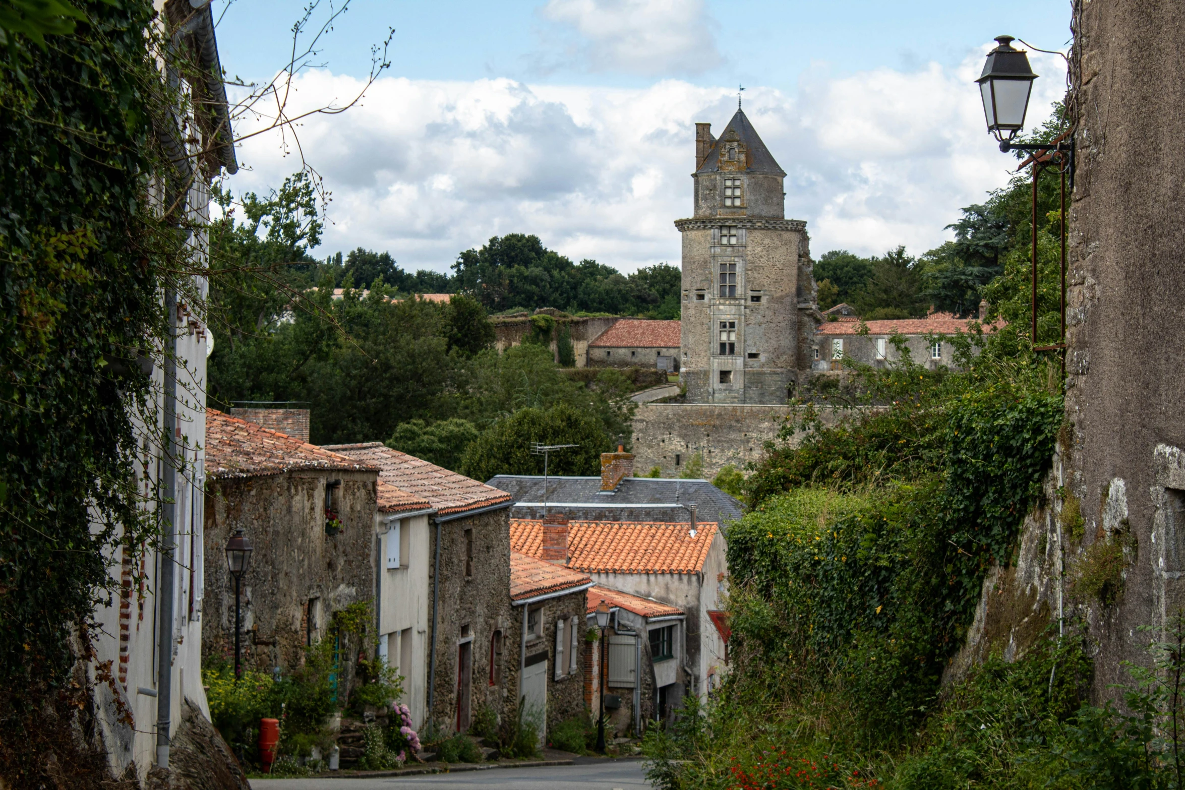 a city street with an old tower and a lantern