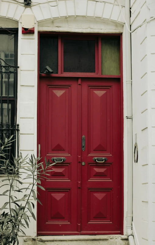 two doors that are red on the side of a building