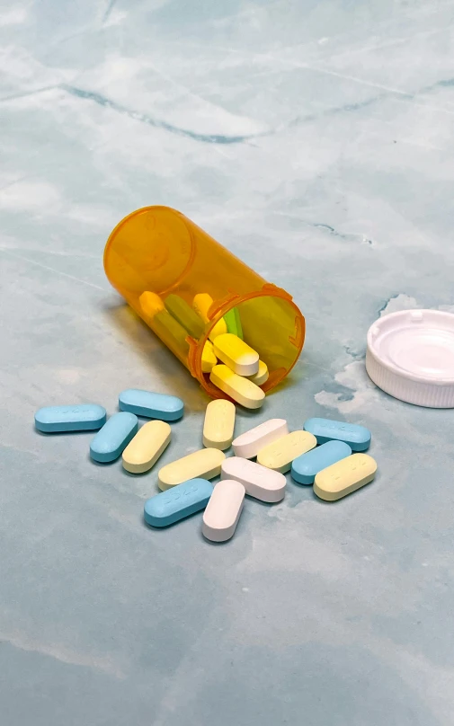 a pile of pills spilling out of an open prescription bottle