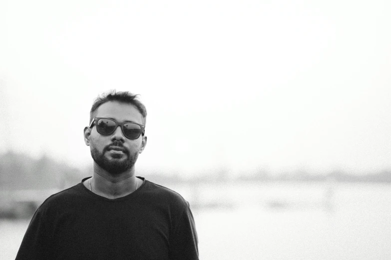 black and white pograph of a man with sunglasses looking off into the distance