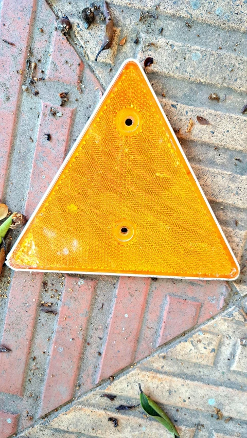 a street sign laying on the pavement on top of bricks