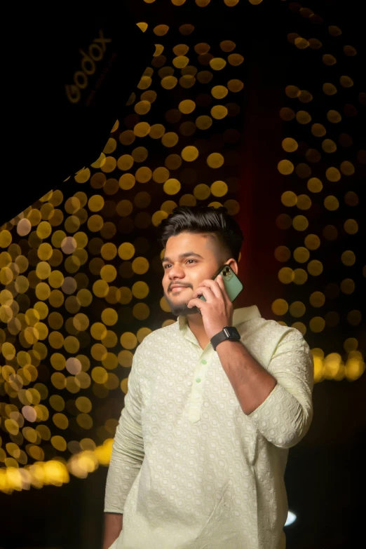 a man standing next to a large building talking on his cell phone