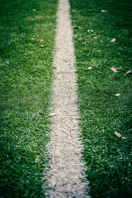 a soccer ball sitting on the ground of an empty field