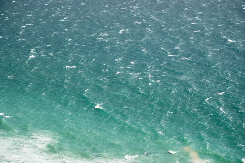 two people standing in the water next to the beach