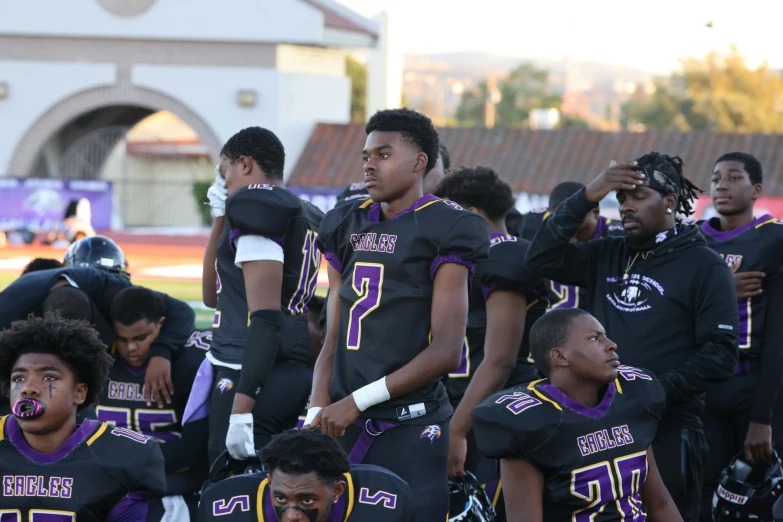 a group of men with purple uniforms are in the middle of a game